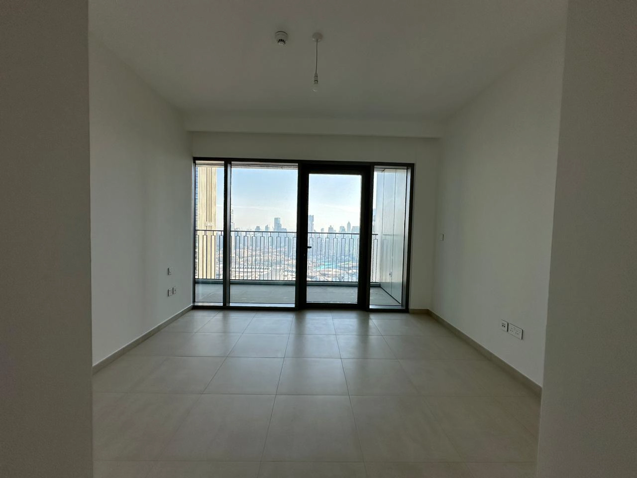 Exterior view of Downtown Views II, a modern apartment complex in Dubai, featuring sleek architectural design with glass facades, and an interior shot of a three-bedroom apartment with contemporary decor, large windows, and luxurious finishes.