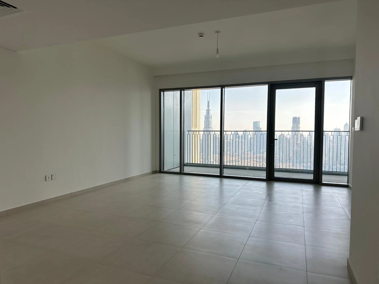 Exterior view of Downtown Views II, a modern apartment complex in Dubai, featuring sleek architectural design with glass facades, and an interior shot of a three-bedroom apartment with contemporary decor, large windows, and luxurious finishes.