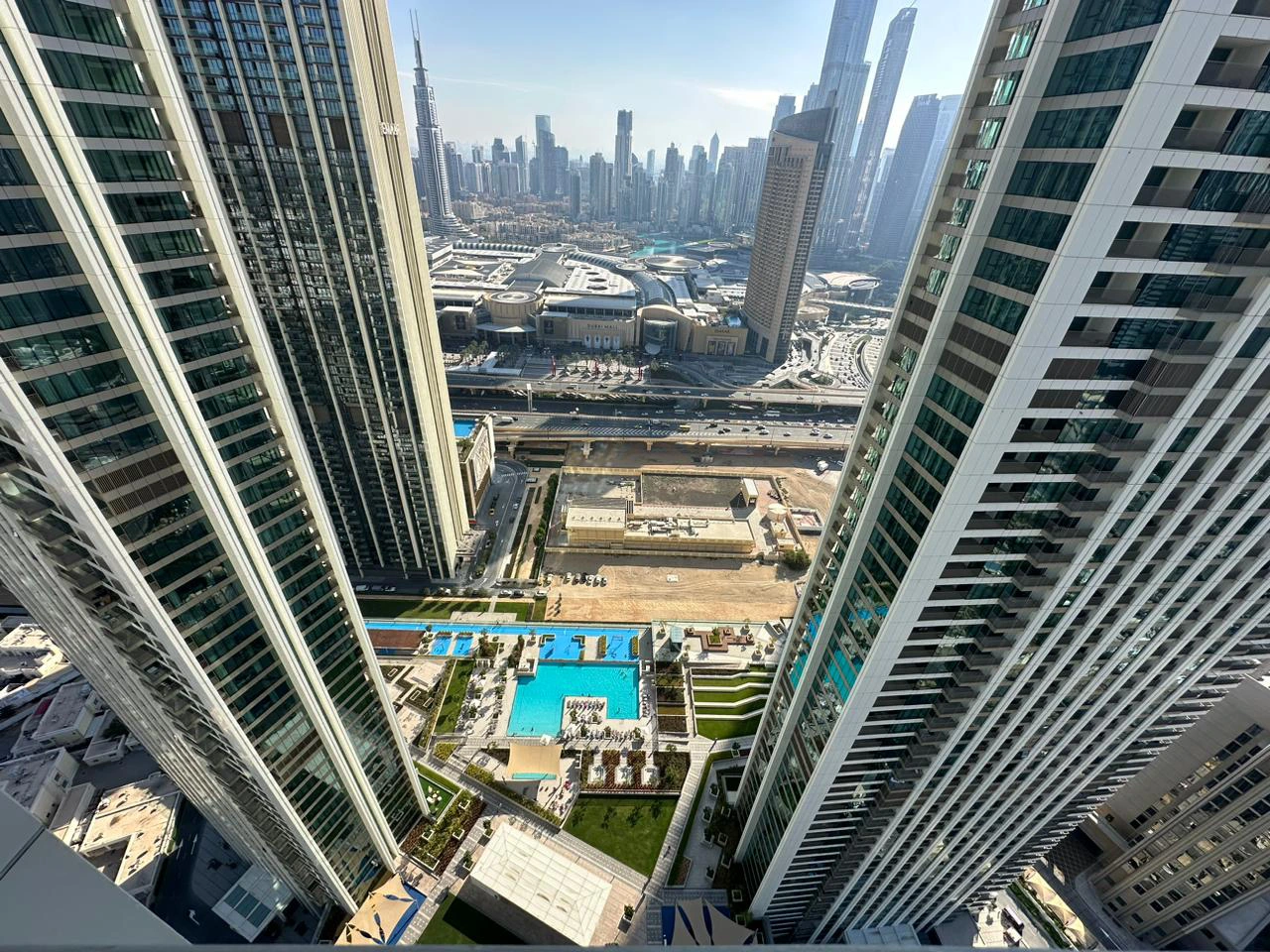 Exterior view of Downtown Views II, a modern apartment complex in Dubai, featuring sleek architectural design with glass facades, and an interior shot of a three-bedroom apartment with contemporary decor, large windows, and luxurious finishes.