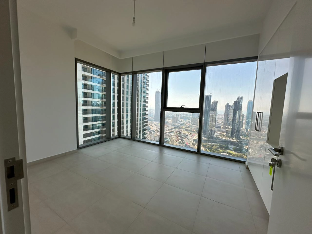 Exterior view of Downtown Views II, a modern apartment complex in Dubai, featuring sleek architectural design with glass facades, and an interior shot of a three-bedroom apartment with contemporary decor, large windows, and luxurious finishes.