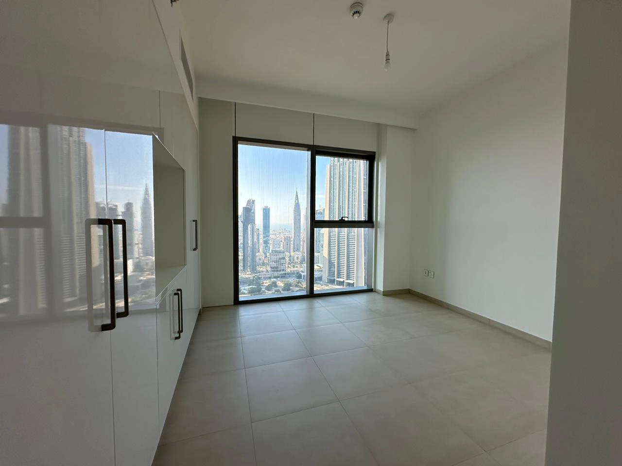 Exterior view of Downtown Views II, a modern apartment complex in Dubai, featuring sleek architectural design with glass facades, and an interior shot of a three-bedroom apartment with contemporary decor, large windows, and luxurious finishes.
