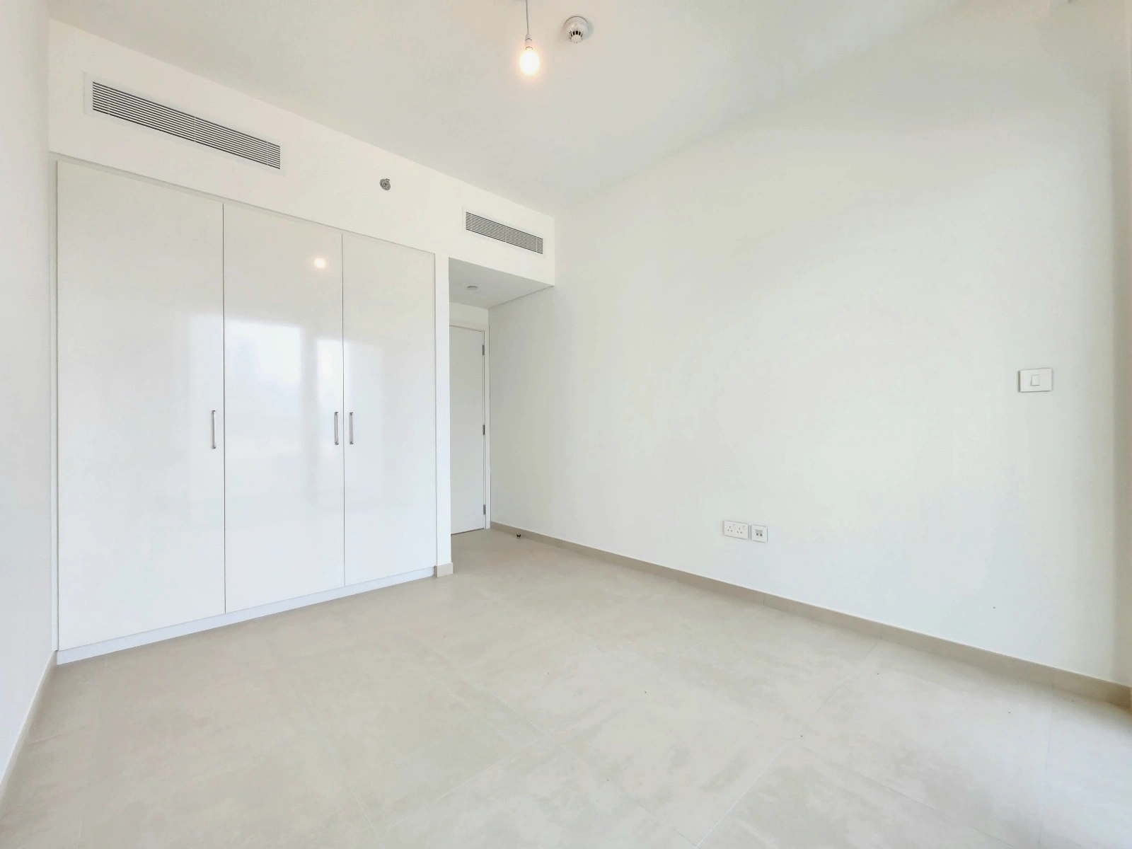 Exterior view of Downtown Views II, a modern apartment complex in Dubai, featuring sleek architectural design with glass facades, and an interior shot of a three-bedroom apartment with contemporary decor, large windows, and luxurious finishes.