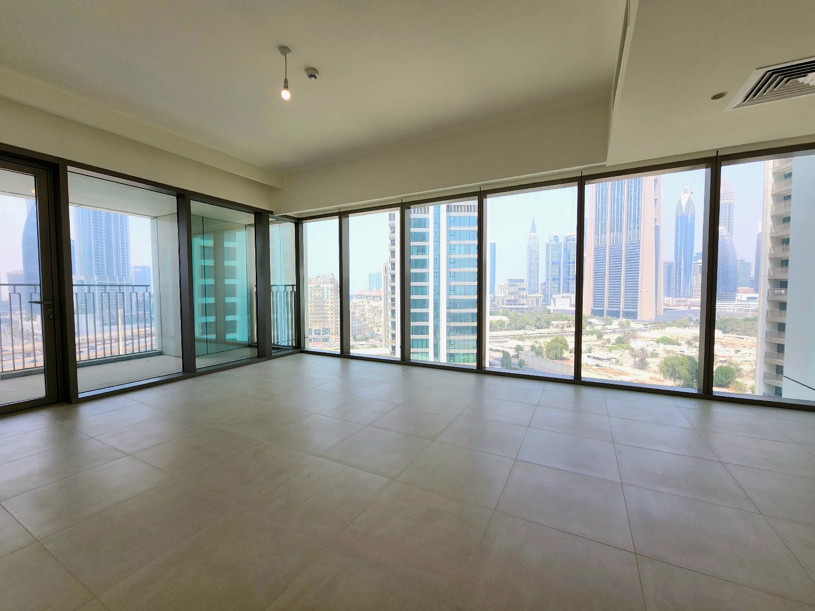 Exterior view of Downtown Views II, a modern apartment complex in Dubai, featuring sleek architectural design with glass facades, and an interior shot of a three-bedroom apartment with contemporary decor, large windows, and luxurious finishes.