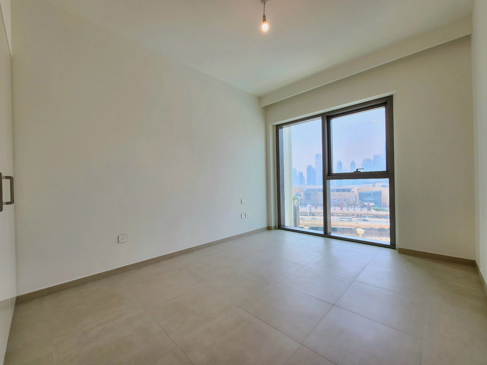 Exterior view of Downtown Views II, a modern apartment complex in Dubai, featuring sleek architectural design with glass facades, and an interior shot of a three-bedroom apartment with contemporary decor, large windows, and luxurious finishes.